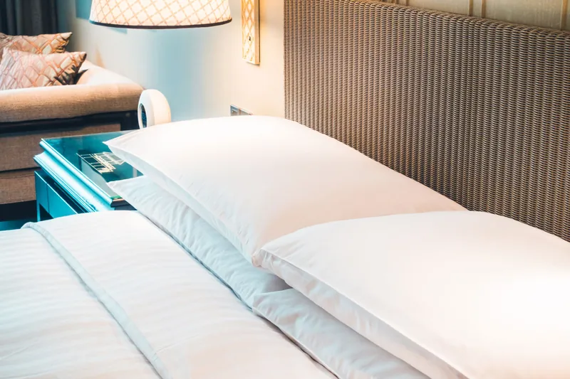 Hotel bed with white bed linen