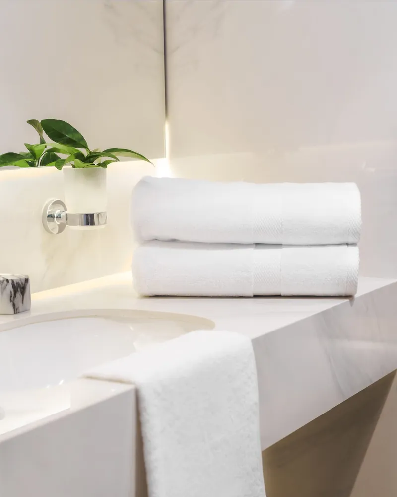 Toallas blancas de hotel BYROSH en un baño